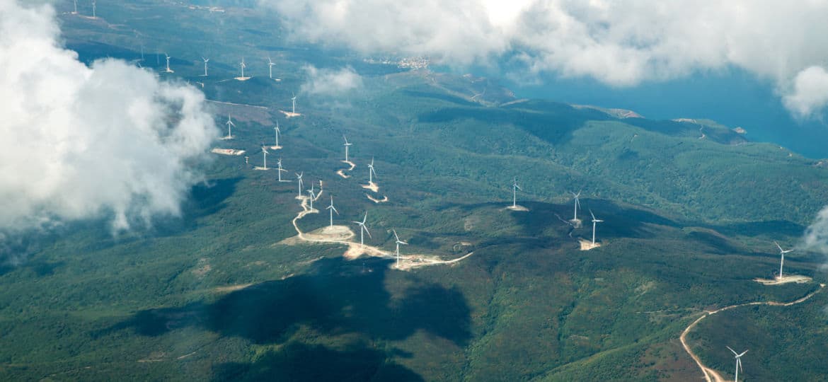 Panorama skyline view of cloudy blue sky from airplane window over wind farm landscape background. Wind turbines renewable power energy stations. Environmentally friendly renewable energy windmill.